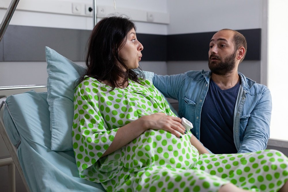 Pregnant woman in labor with partner support during painless delivery in Indore